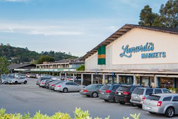 a parking lot in front of a market with cars parked